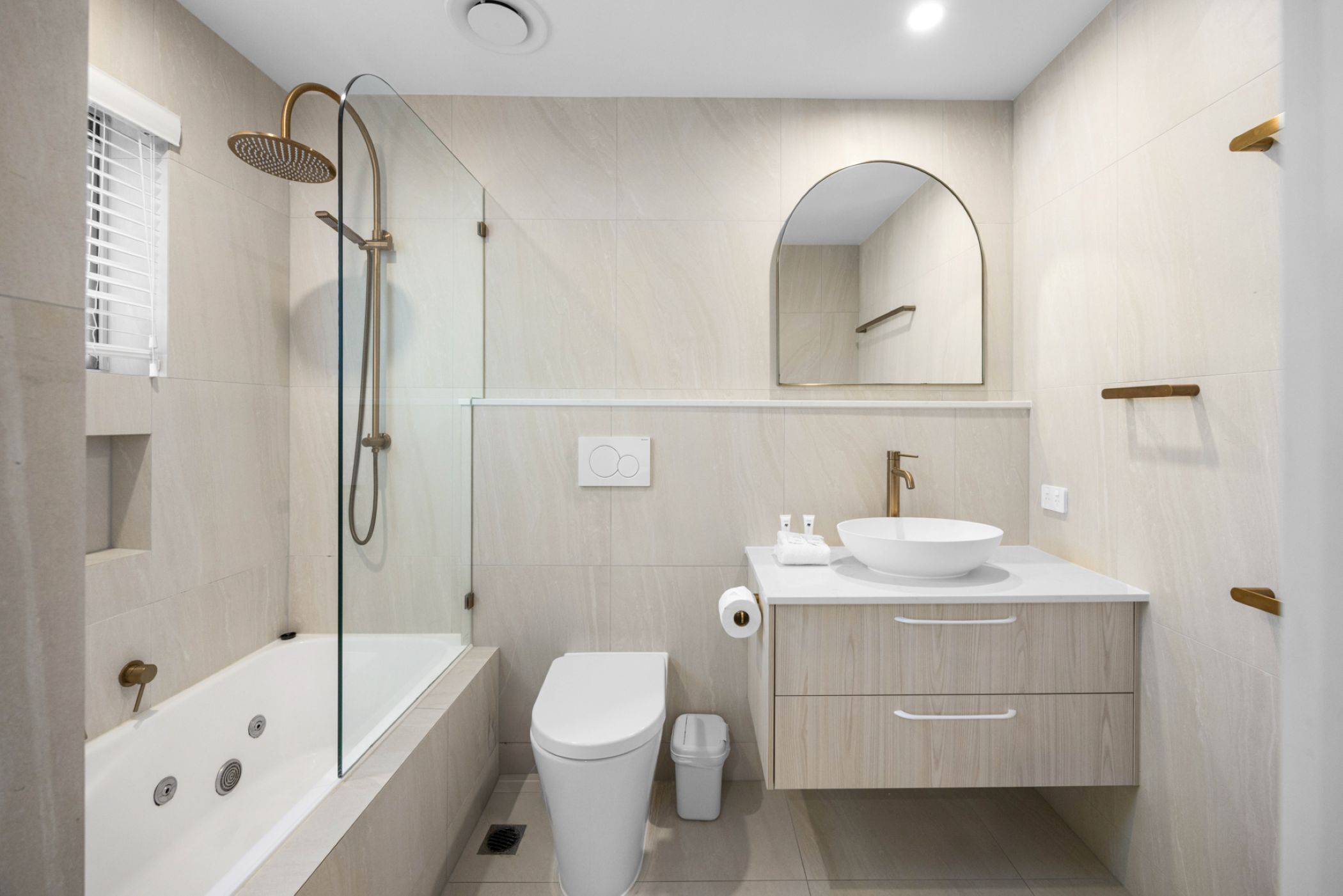 A modern bathroom with a bathtub, toilet, sink, and shower.