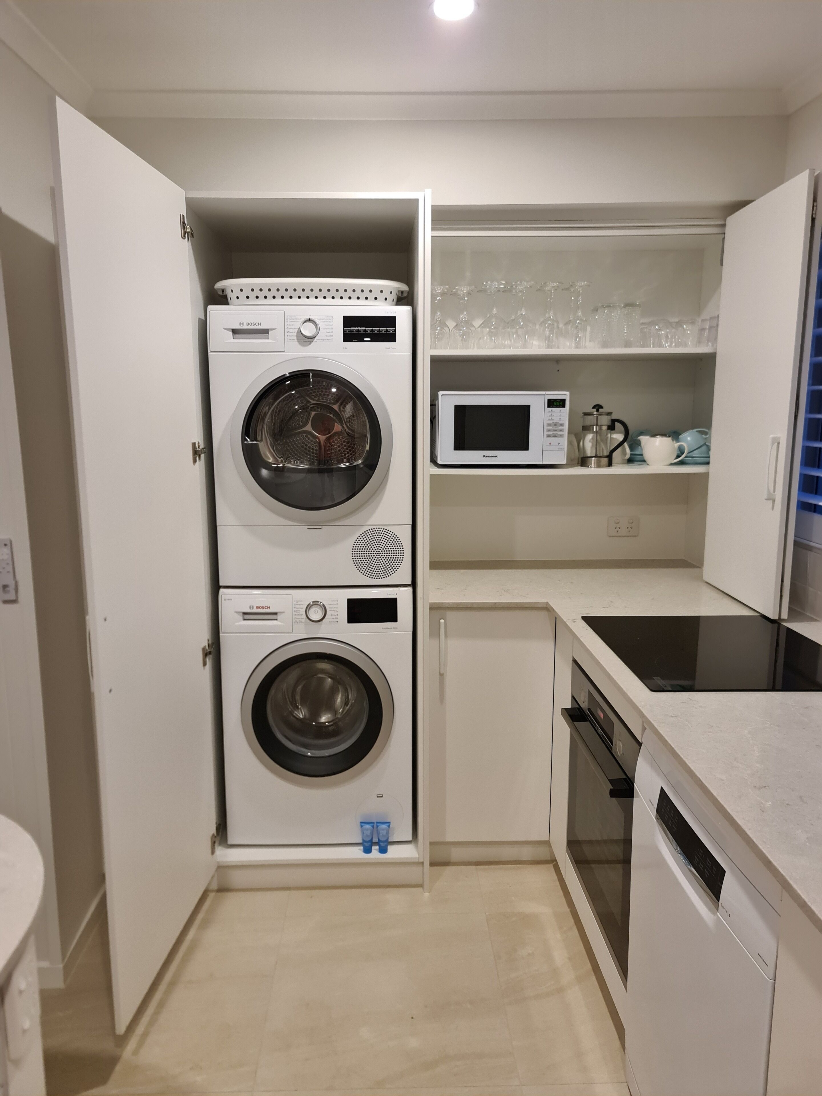 Une cuisine compacte équipée d’un lave-linge Bosch, d’un four à micro-ondes et d’un lave-vaisselle.