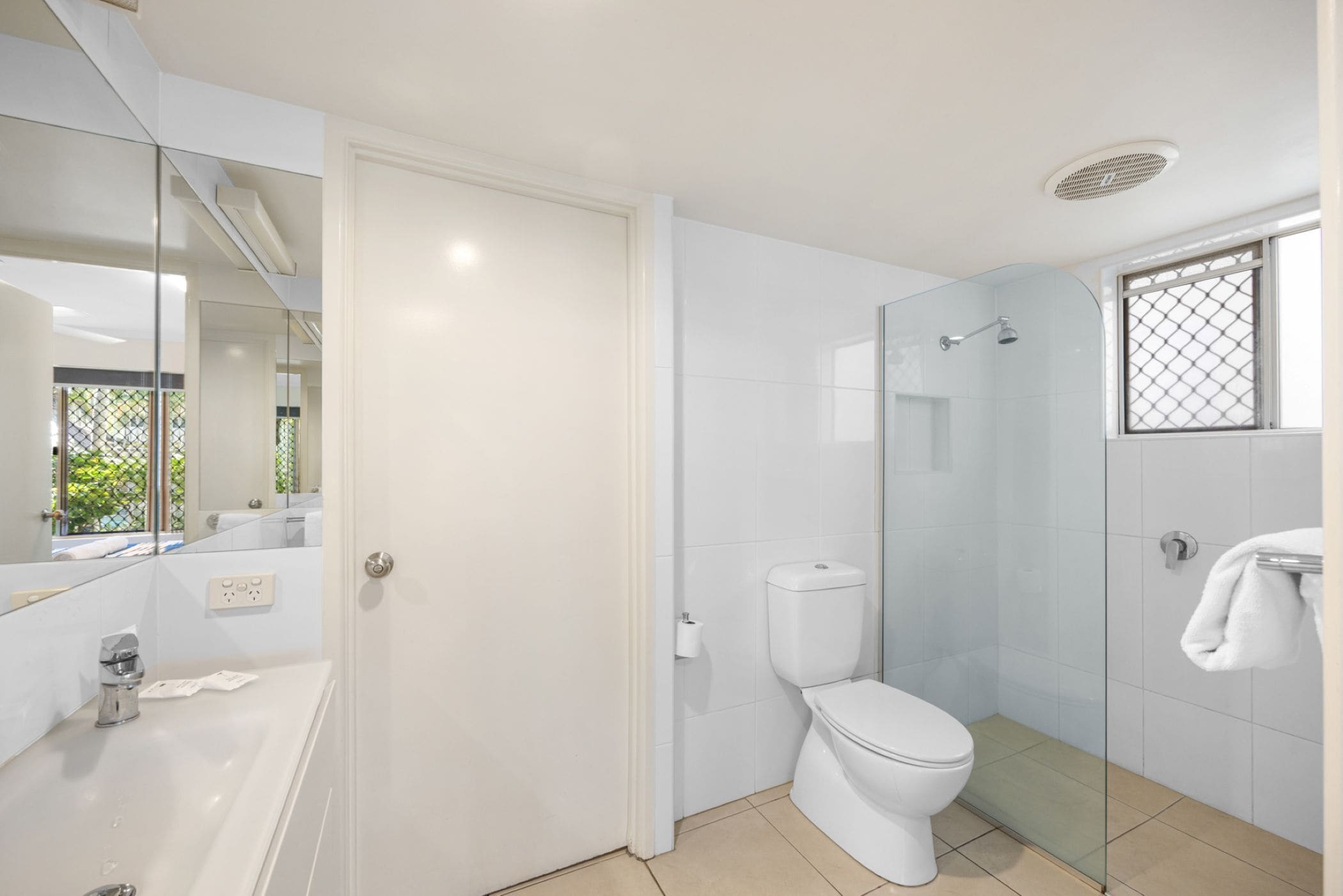 A modern bathroom with a glass shower enclosure, a white toilet, and a bathtub.