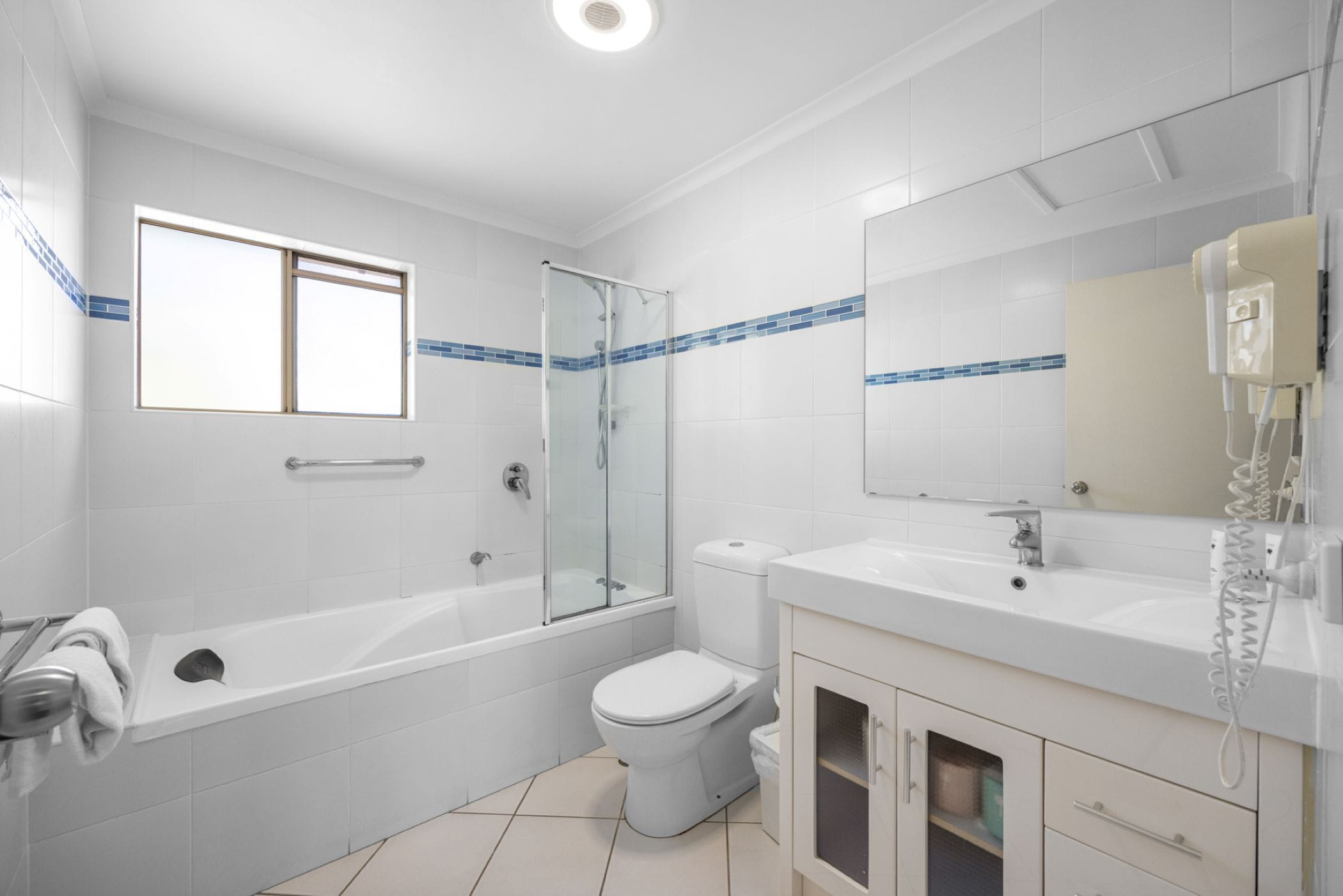 A modern bathroom with a bathtub, toilet, and shower area.