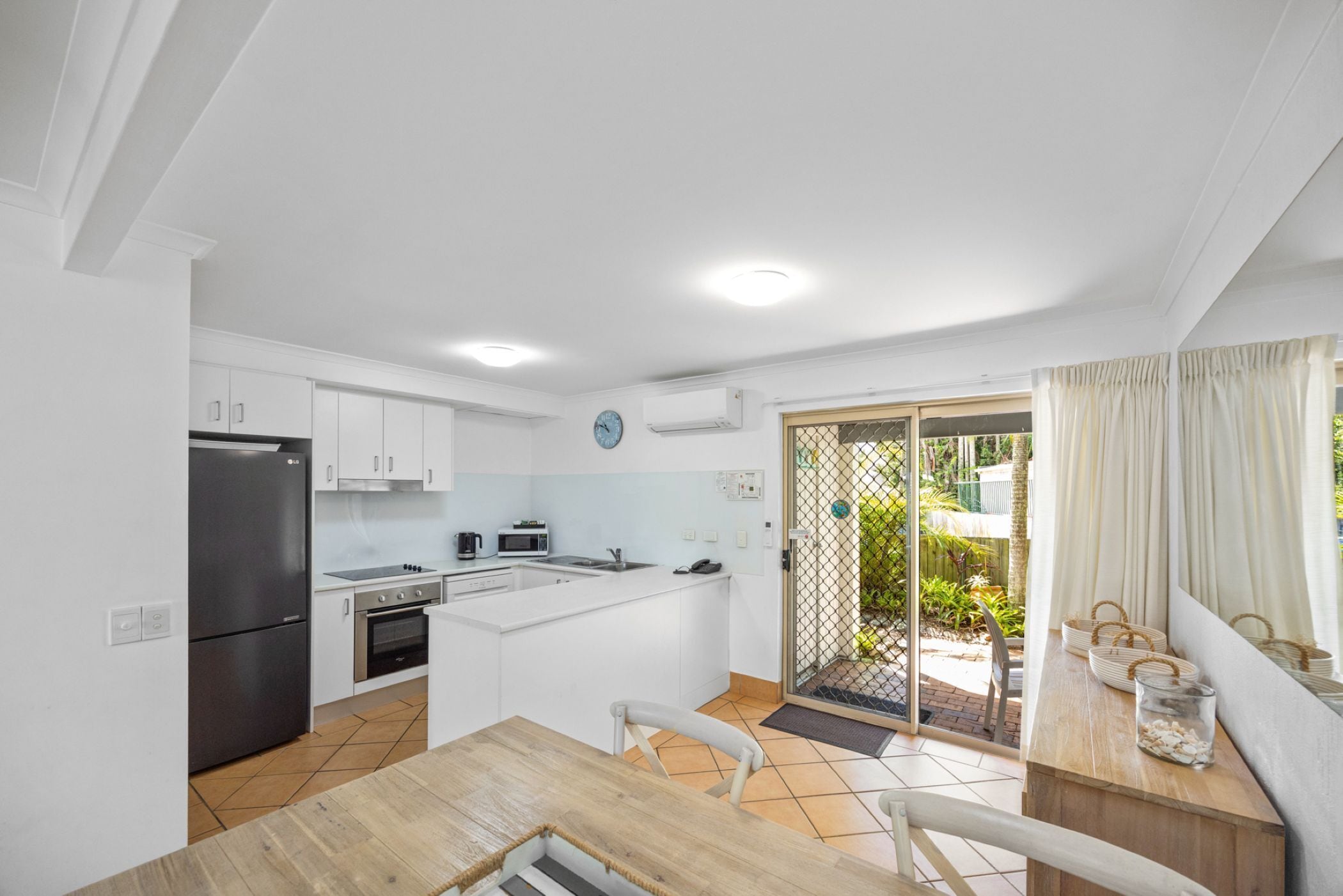 A compact kitchen with a refrigerator, stove, microwave, and sink.