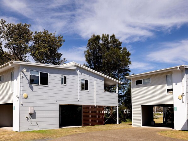 Un immeuble résidentiel moderne à deux étages, avec un garage au rez-de-chaussée.
