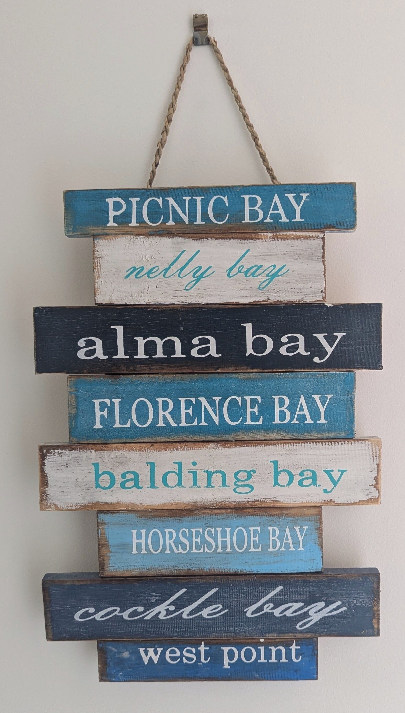 A wooden sign with names of bays.