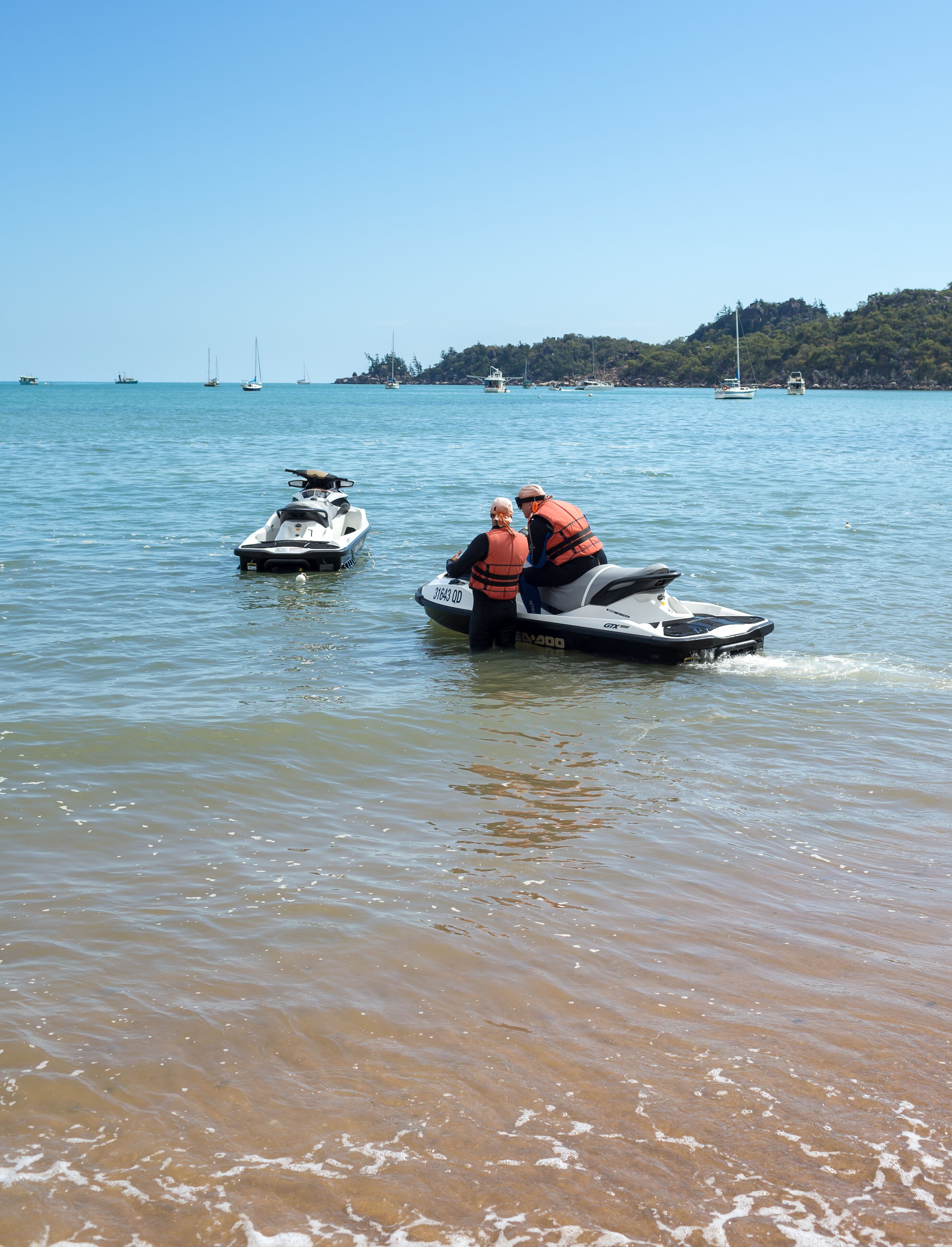 Un lac avec deux jet-skis et un petit bateau.
