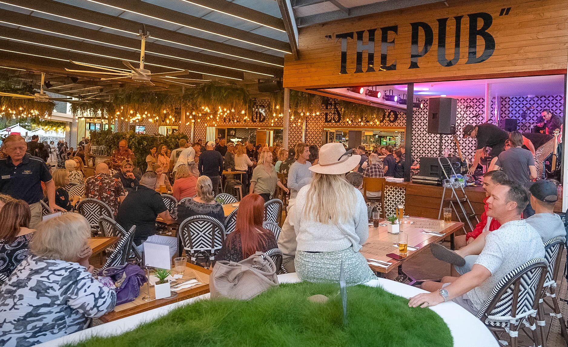 Ein lebhaftes Pub-Interieur mit Holzeinrichtung und einem Schild mit der Aufschrift "THE PUB".