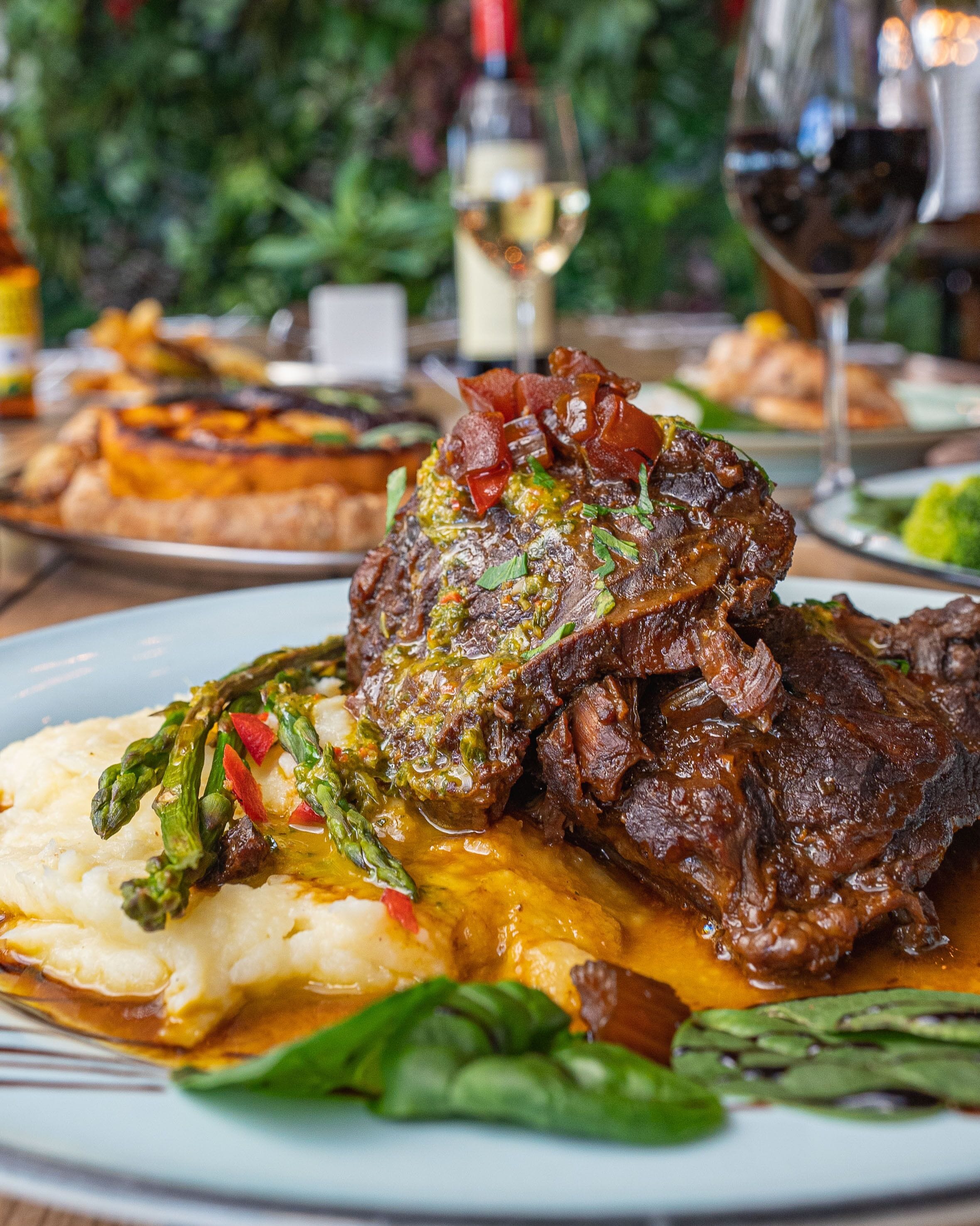 A plate of beef with vegetables and mashed potatoes.