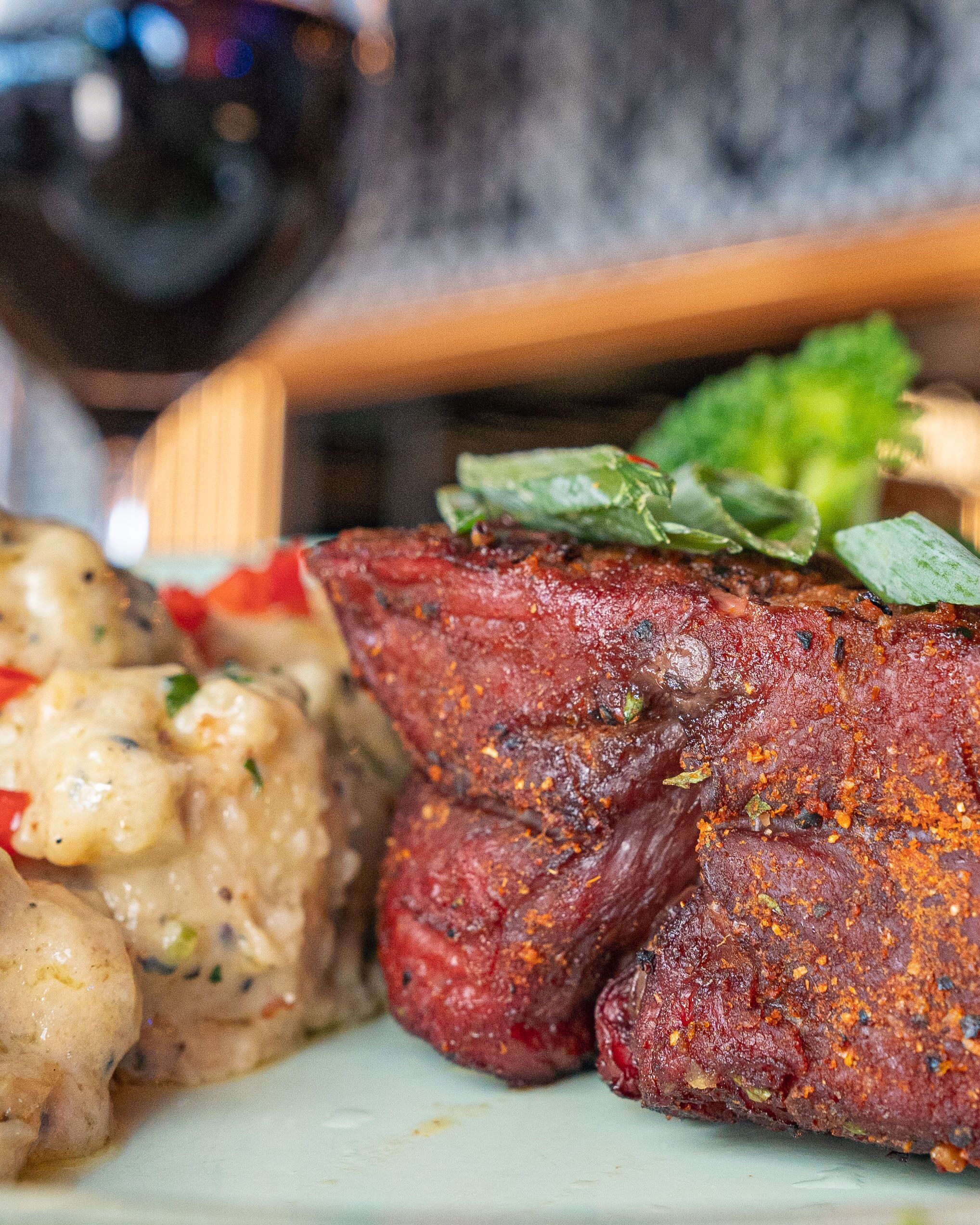 Un plato con un bistec, salsa cremosa y un acompañamiento.