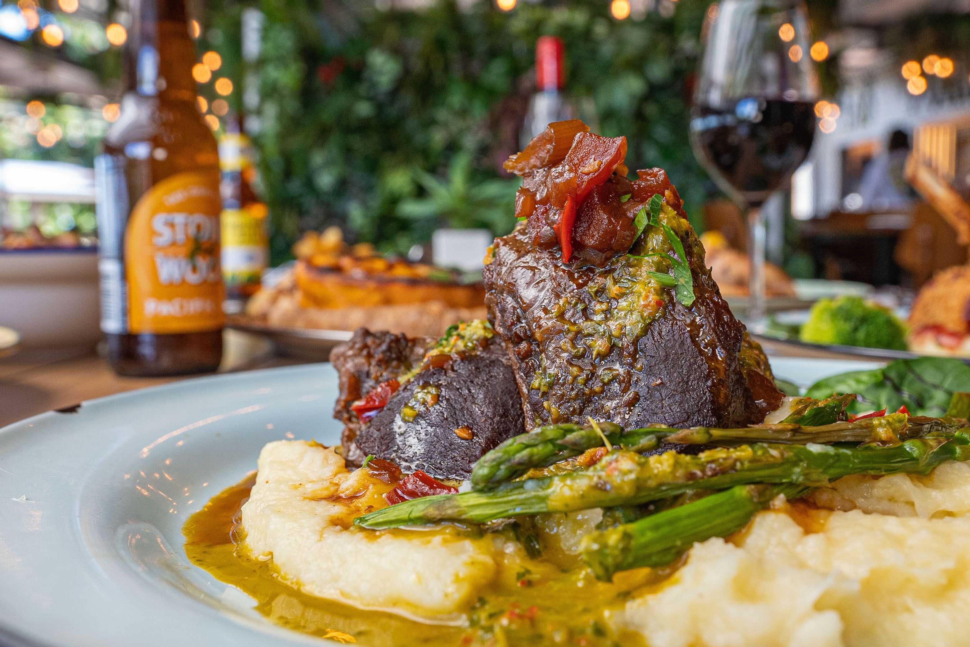 Une assiette de nourriture comprenant un steak, des asperges et de la purée de pommes de terre.