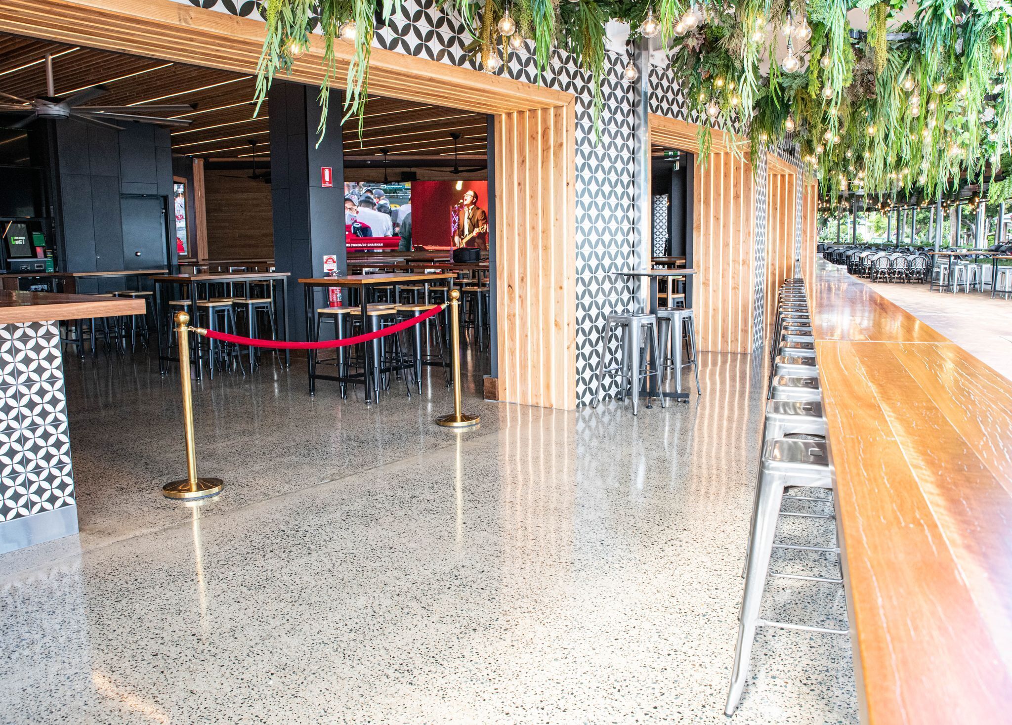 Ein modernes Restaurantinterieur mit einem gefleckten Boden, Holzakzenten und einer roten Baustellenabsperrung.