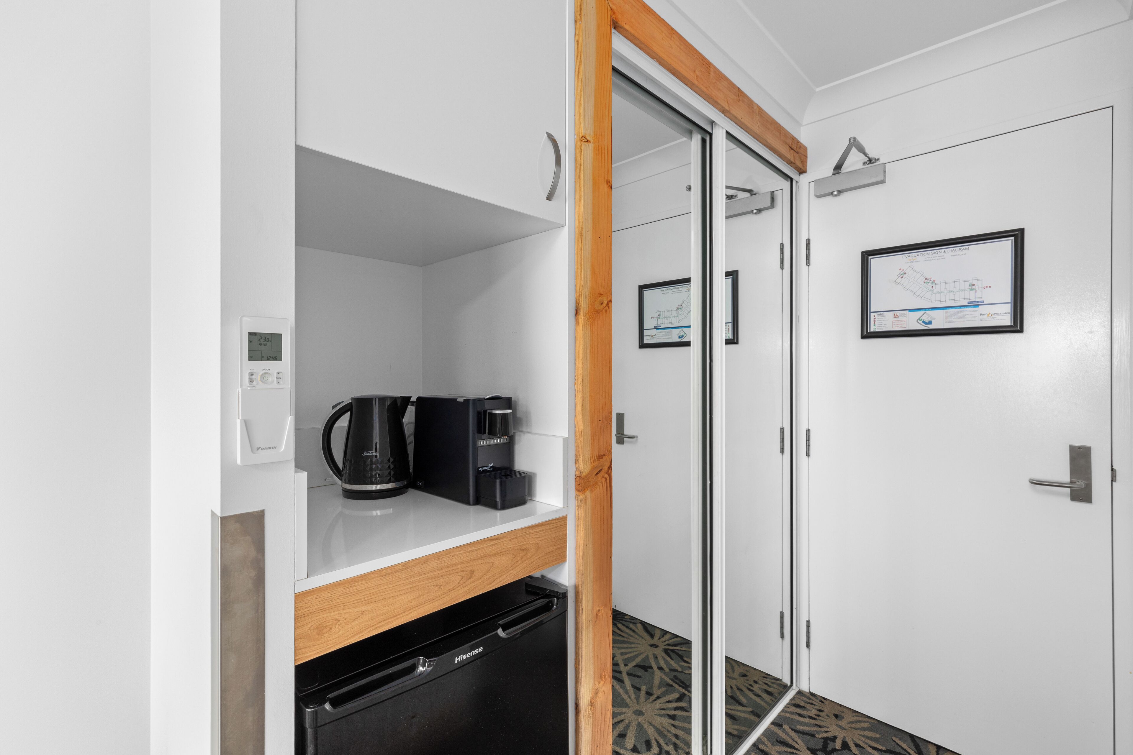A compact kitchen with a coffee maker, a dishwasher, and a cabinet.