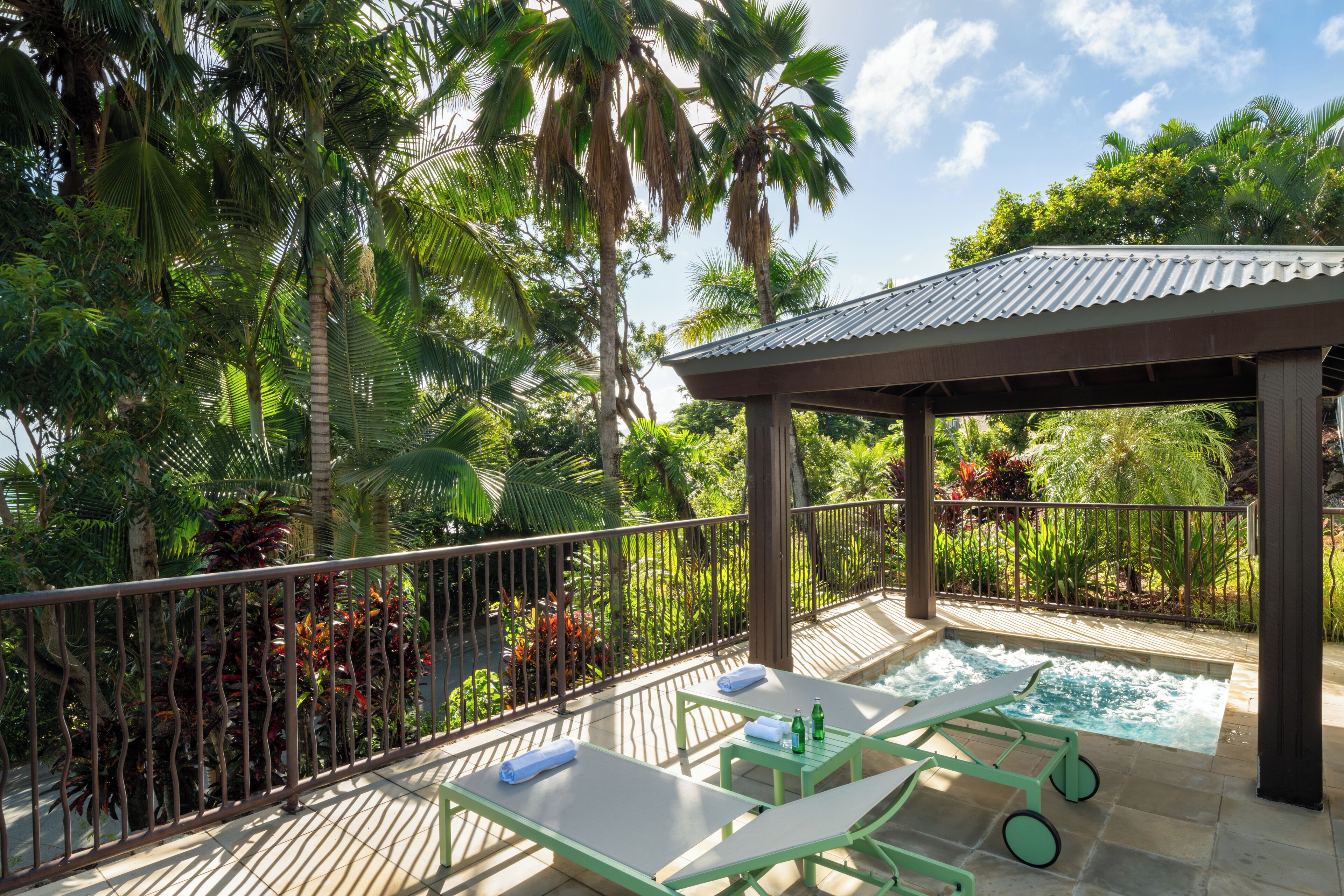 Un espacio al aire libre techado con piscina, sillas de descanso y una pérgola.
