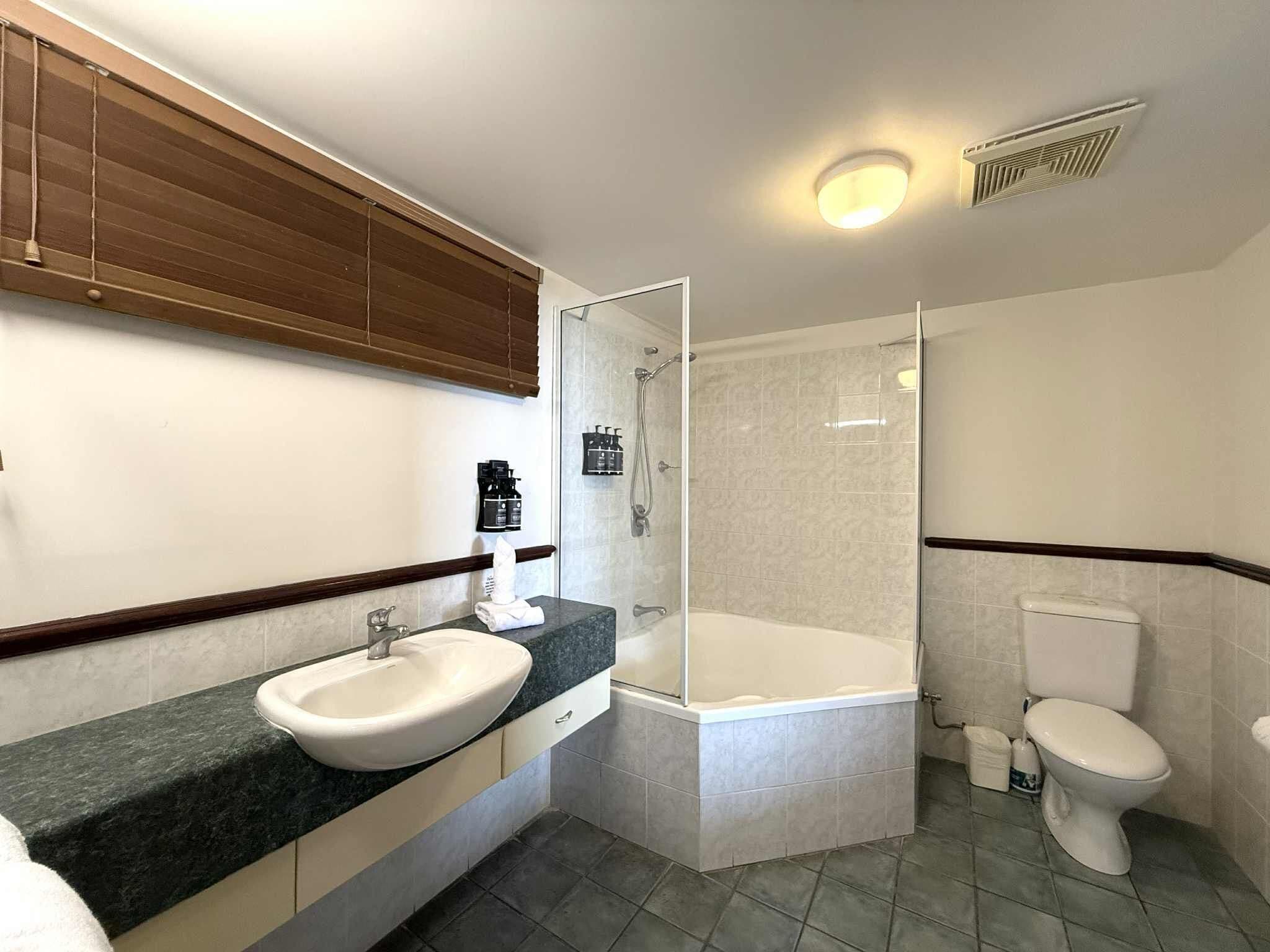A modern bathroom with a sink, toilet, and shower.