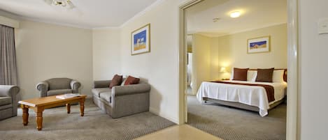 Una habitación de hotel con una cama, un sofá, una mesita y una silla.