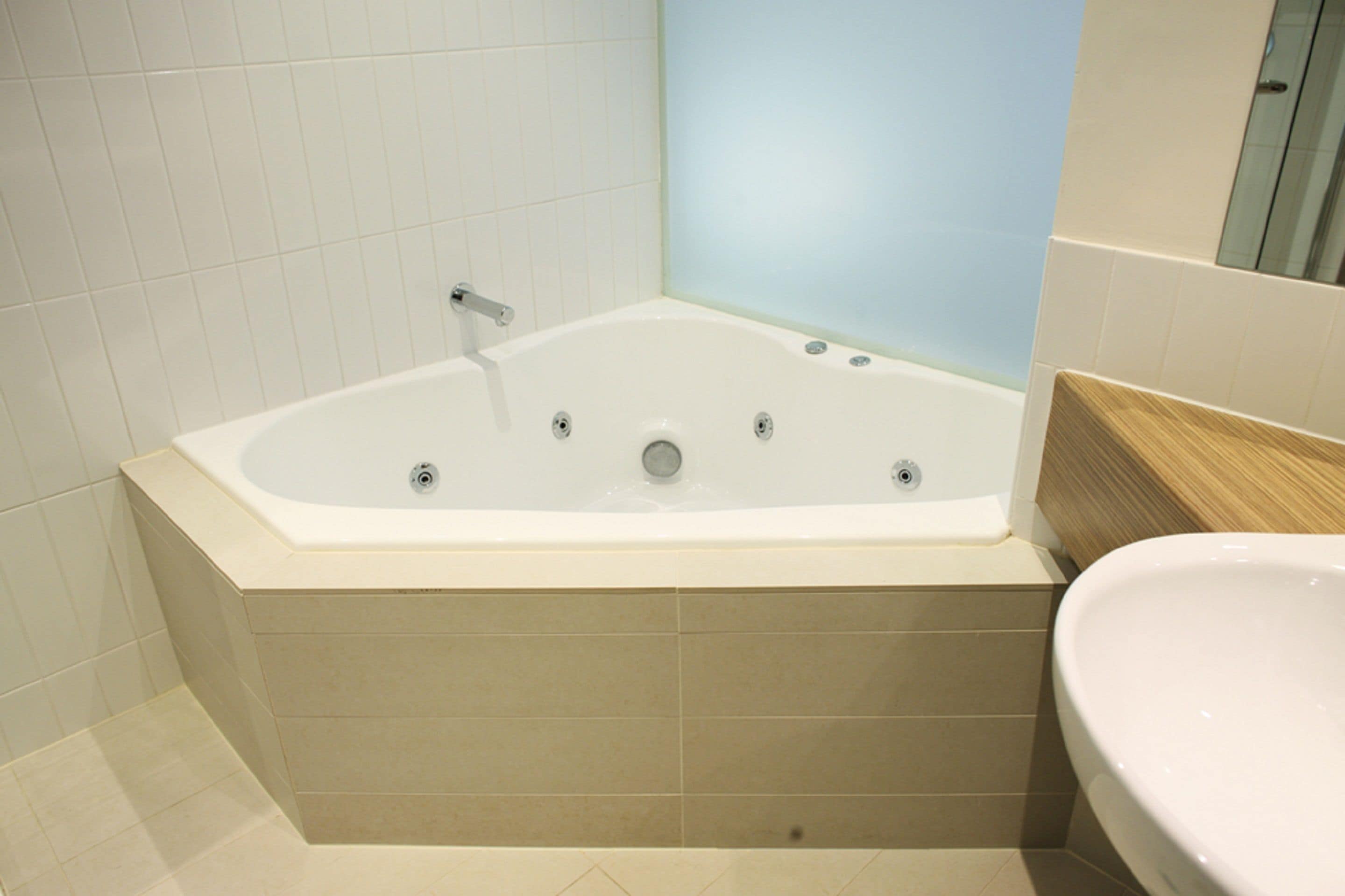 A modern bathroom with a freestanding bathtub, a sink, and a mirror.