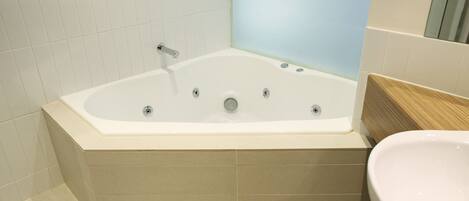 A modern bathroom with a freestanding bathtub, a sink, and a mirror.