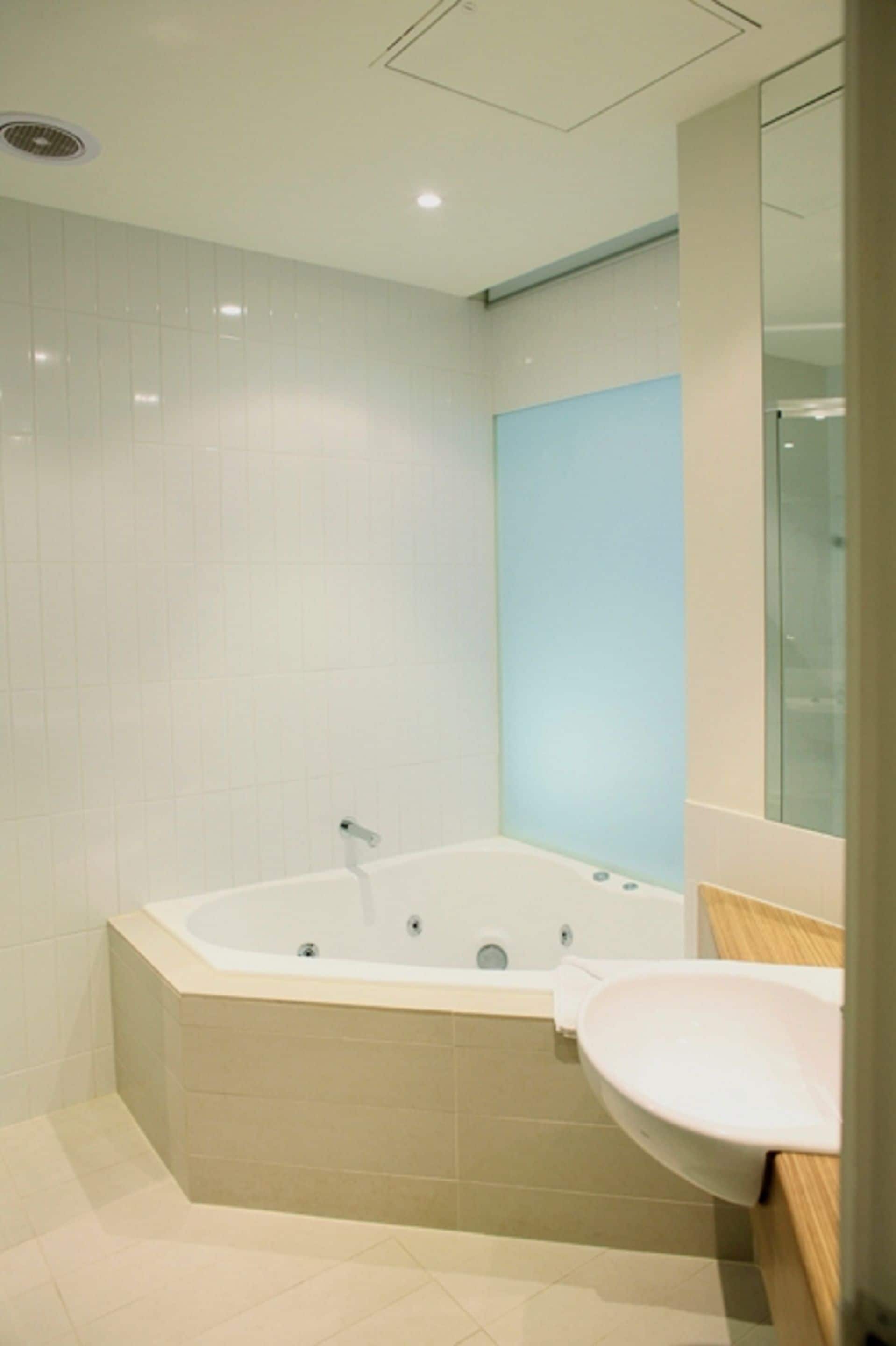 A modern bathroom with a freestanding bathtub, a sink, and a glass shower enclosure.