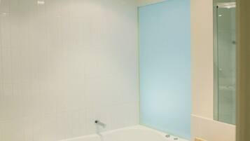 Une salle de bain moderne avec une baignoire sur pieds, un lavabo et une douche à parois de verre.