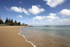 Enjoy a serene beach experience with a view of the horizon from the pier.
