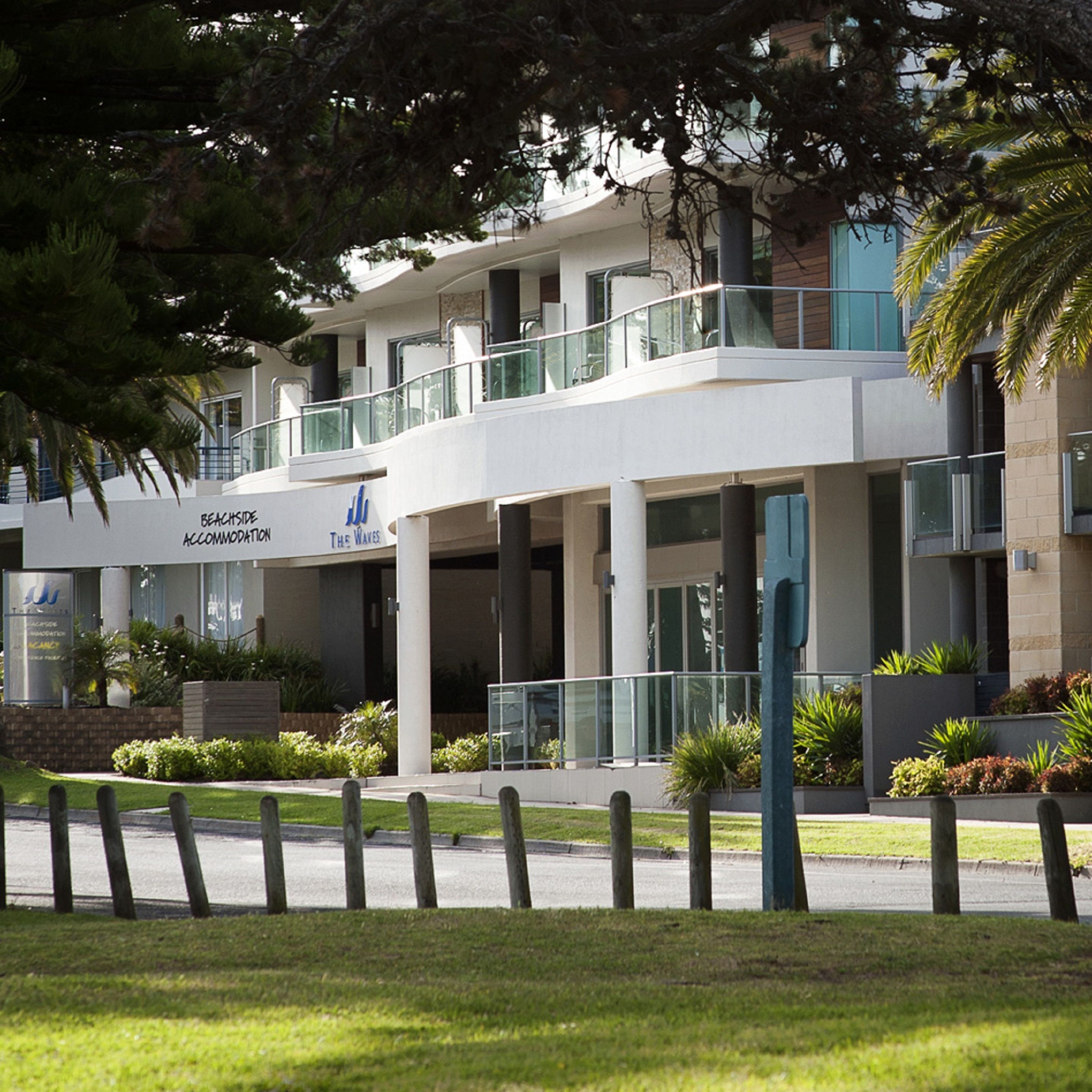 Un edificio moderno con un letrero que dice 'Beachside Accommodation The Waves'.