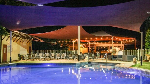 A pool area with a covered seating area and string lights. - Lily Lagoon Resort (Kununurra)