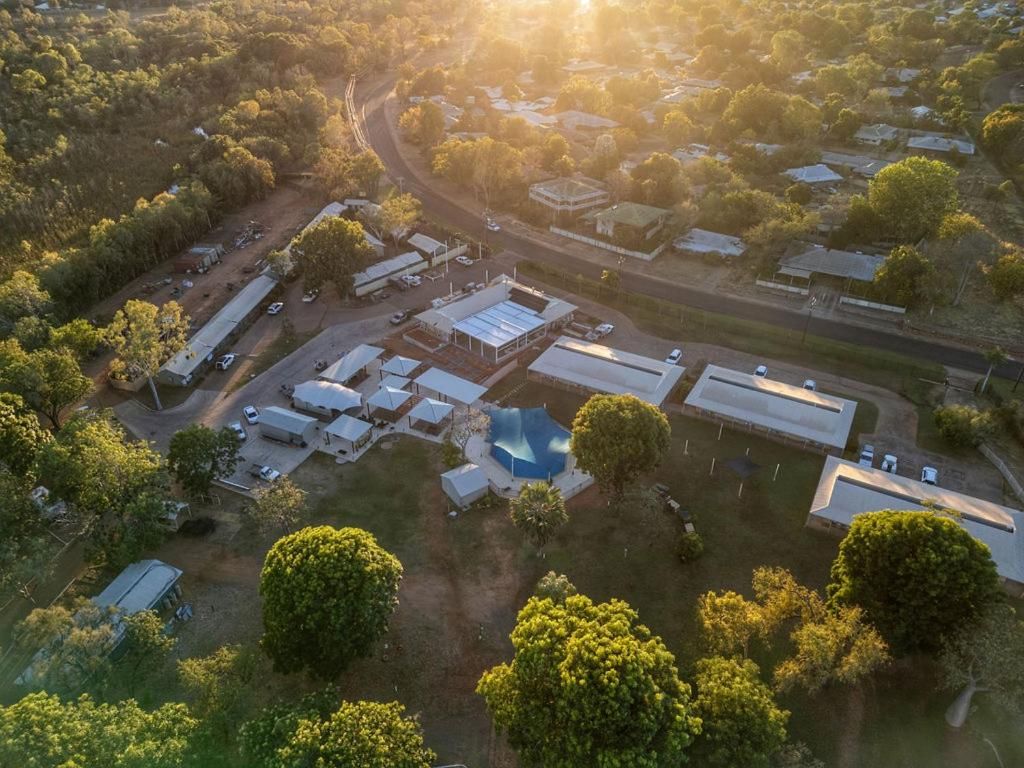 Vista aérea de una zona residencial con varios edificios, calles y vegetación.