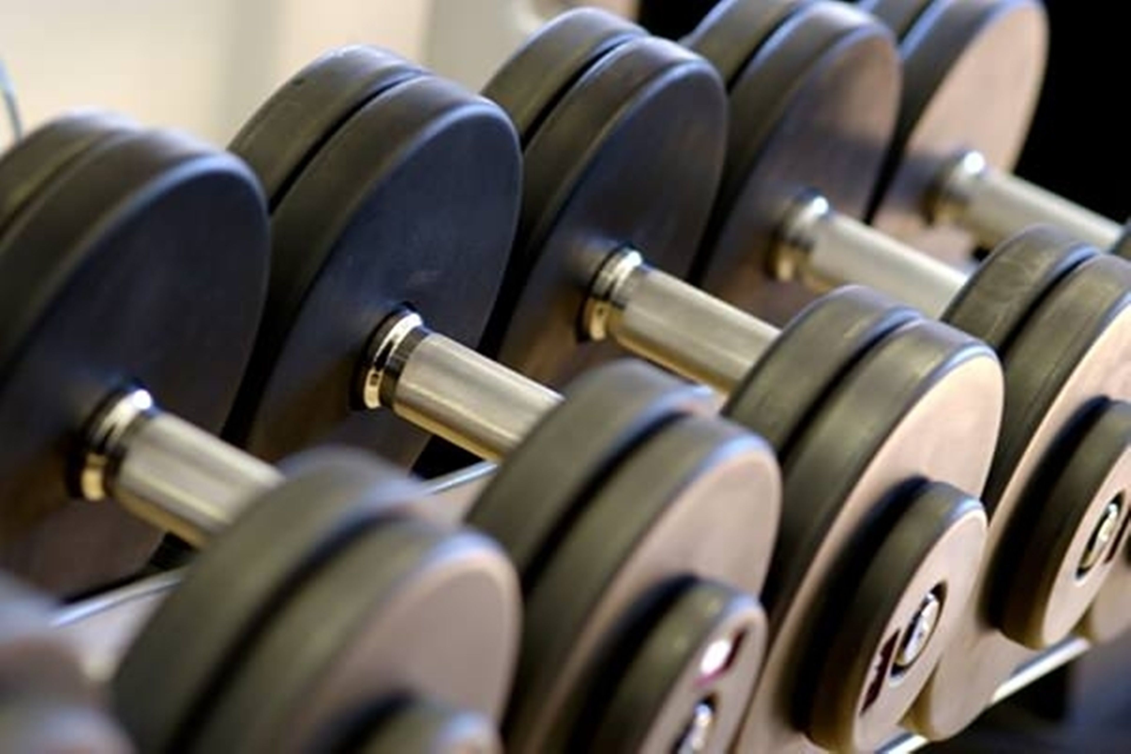 A set of black dumbbells with silver weights and a metallic bar.