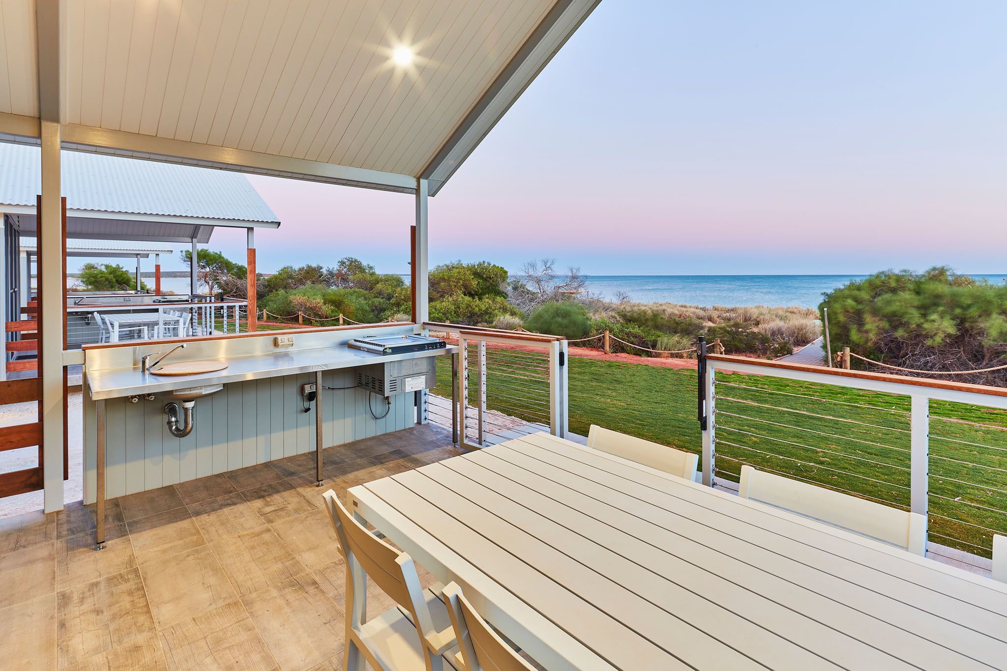 Una zona de cocina al aire libre con vista a la playa y al océano.