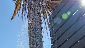 A showerhead with water flowing down a vertical surface.