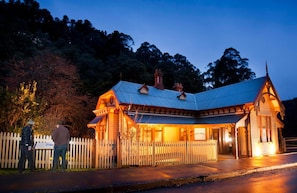 A historic building with a peaked roof, wooden exterior, and a white picket fence in front. - Walhalla's Star Hotel (Walhalla)