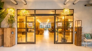 A spacious lobby with a modern design, featuring a central seating area with multiple chairs and tables, and a large glass door entrance. - Capo Peloro Resort - Adults Only (Messina)