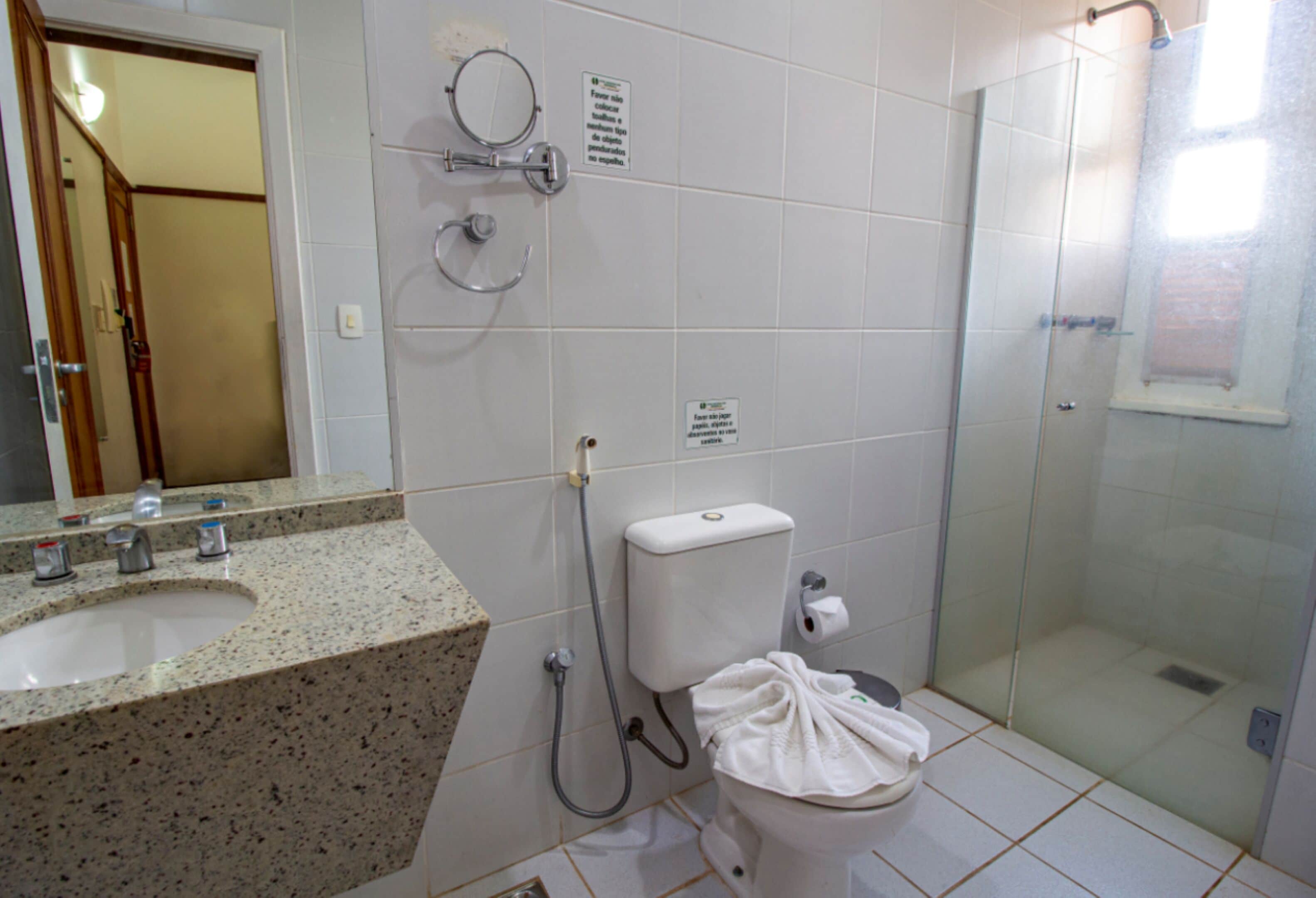 A bathroom with a sink, toilet, and glass-enclosed shower.