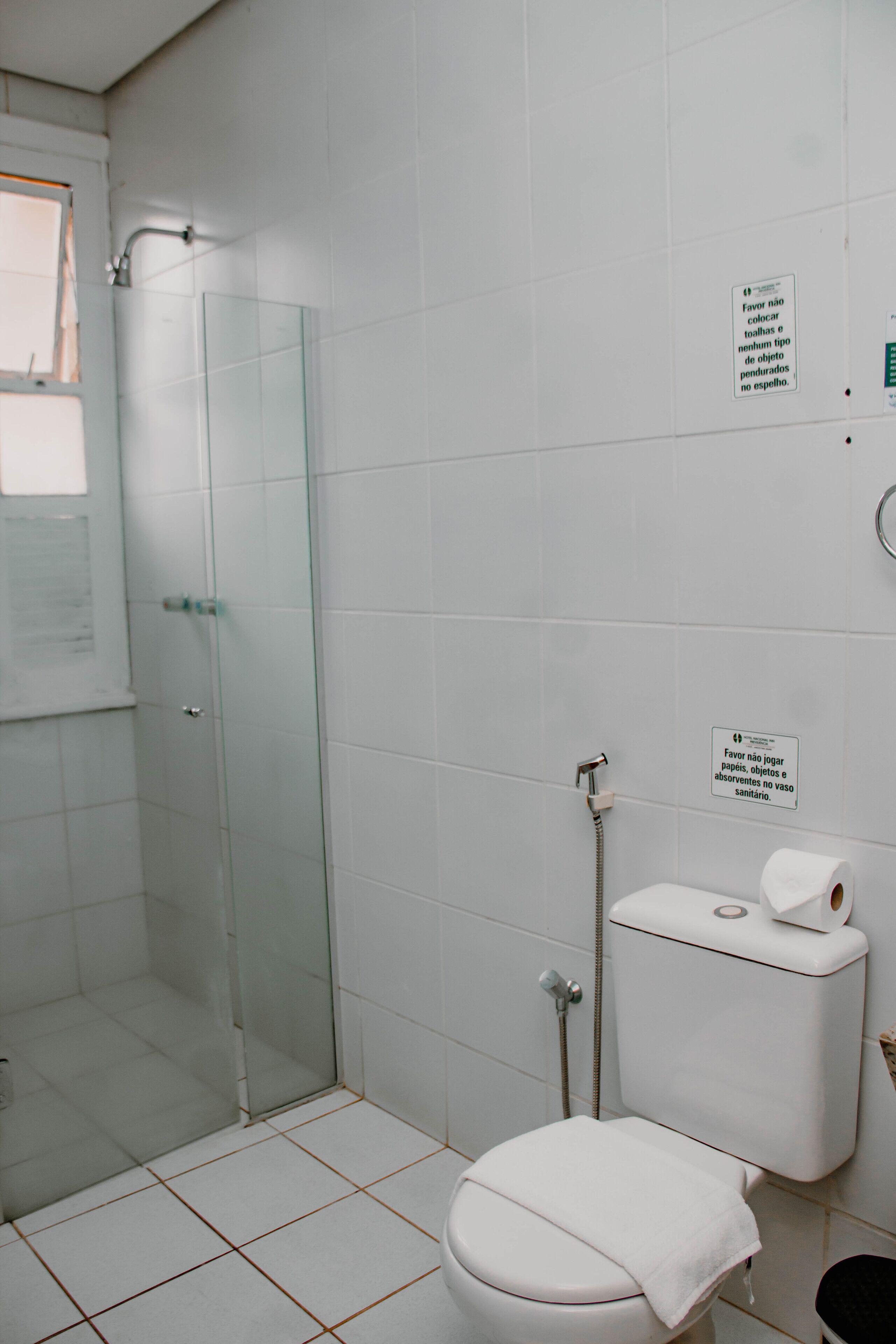 Un baño con cabina de ducha de vidrio, inodoro y lavamanos.