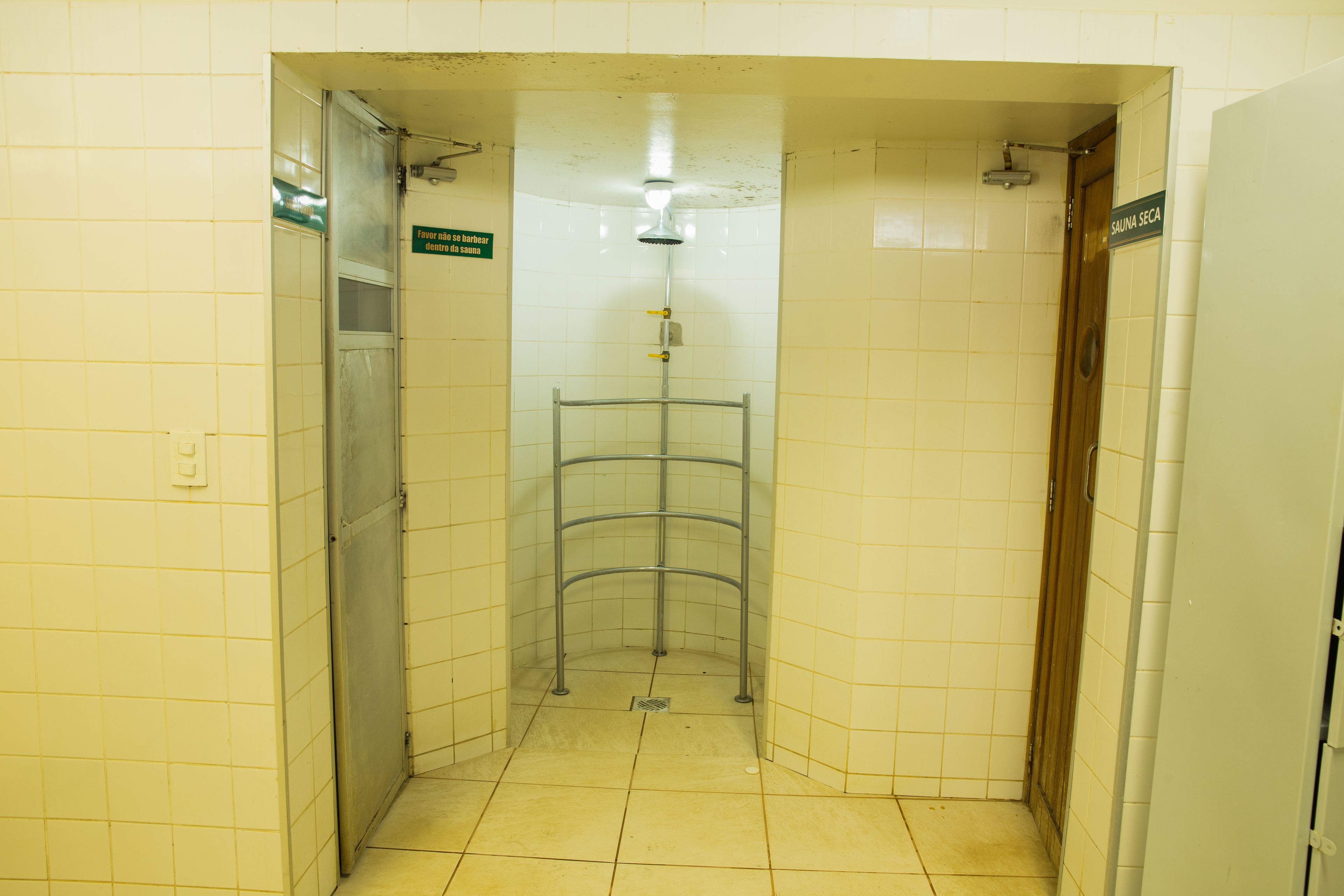 Un baño pequeño con azulejos, que incluye una ducha, un inodoro y un lavabo.
