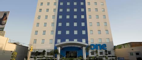 Un hotel con un llamativo letrero que dice 'one hotel', una fachada moderna y un área de entrada despejada.