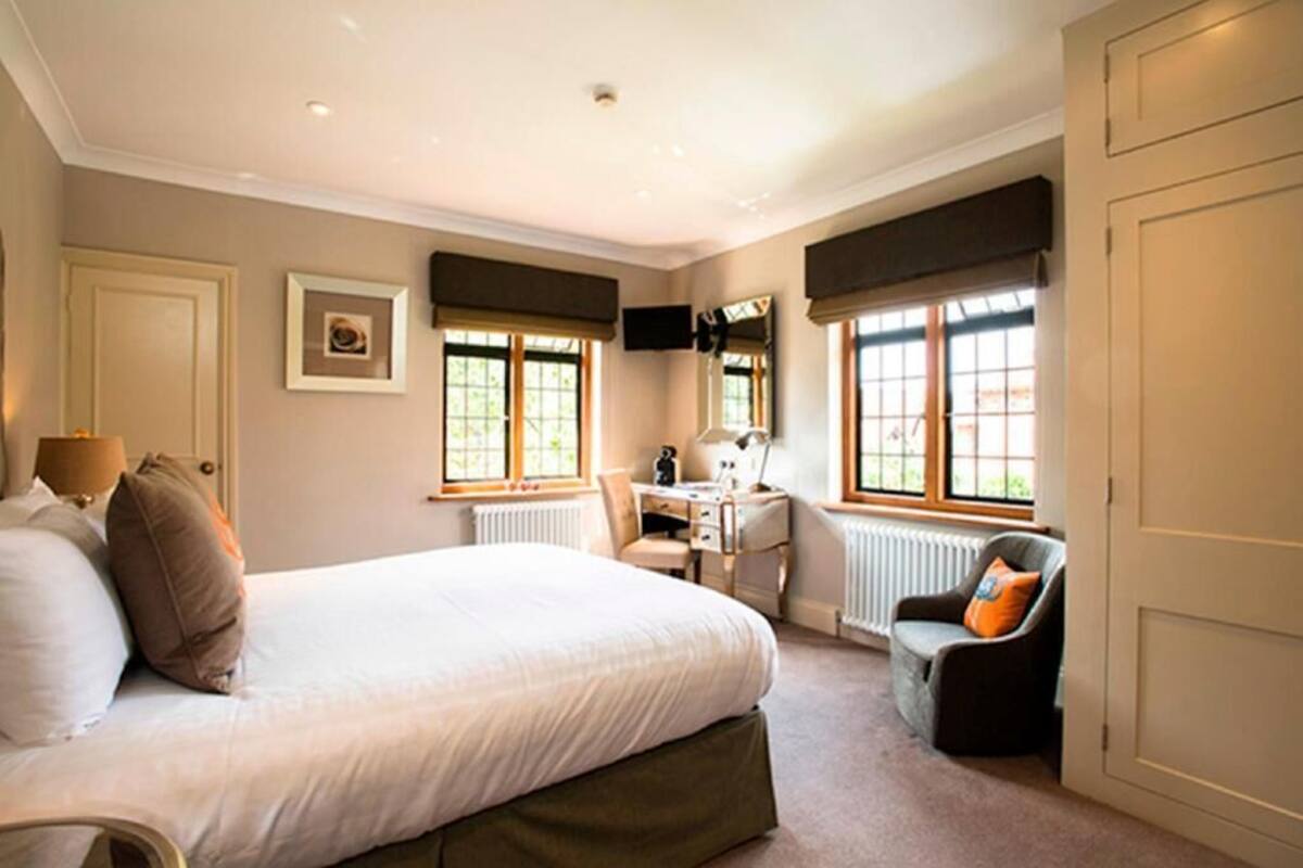 A bedroom with a bed, a desk, a chair, and a radiator.