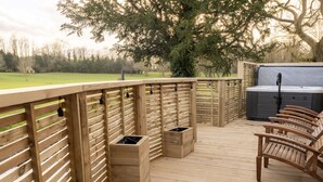 A wooden deck with a hot tub, wooden benches, and trash bins. - Hall Garth Hotel Darlington, Sure Hotel Collection by BW (Darlington)