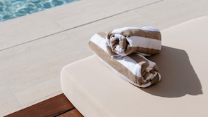 A poolside area with a lounge chair and a towel. - Marina Resort - Adults Only (Nelson Bay)