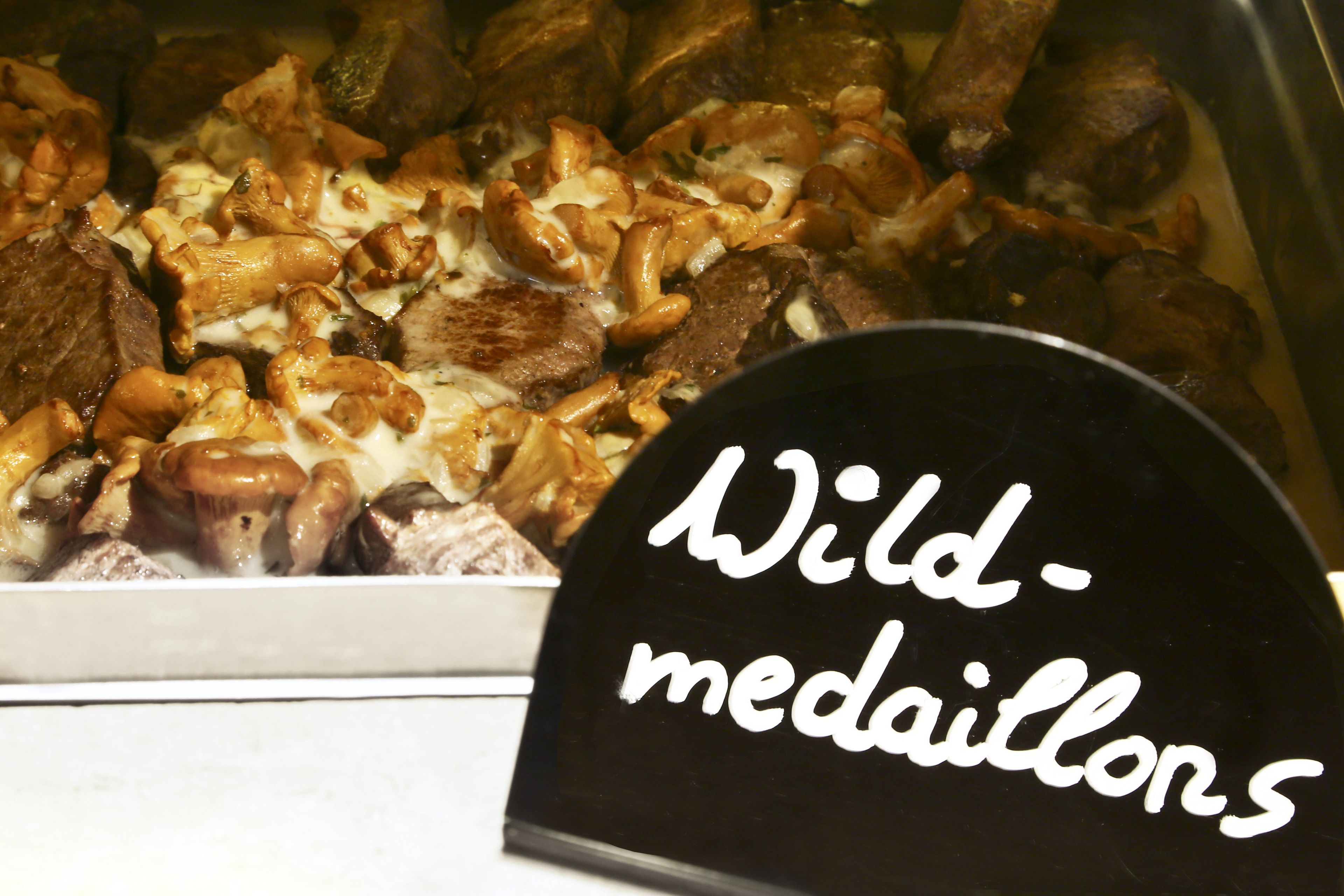 A display of food items with a sign reading "Wild-medallions".