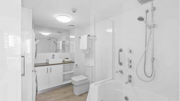 Une salle de bain moderne équipée d’une douche, de toilettes et d’un lavabo.