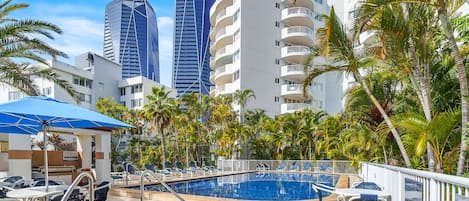 Una piscina al aire libre, sillones reclinables de piscina