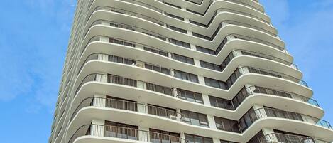 Un hotel alto con fachada curva, balcones y un cartel que dice "Surfers Aquarius".