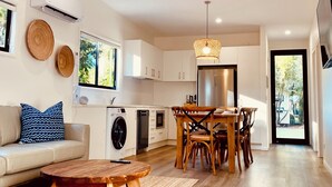 Eine moderne Küche mit weißen Schränken, einem eingebauten Backofen und einem Edelstahl-Kühlschrank.