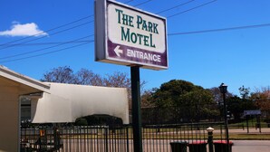 Letrero de motel con una flecha que indica a la izquierda la entrada.