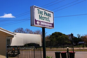 Letrero de motel con una flecha que indica a la izquierda la entrada.