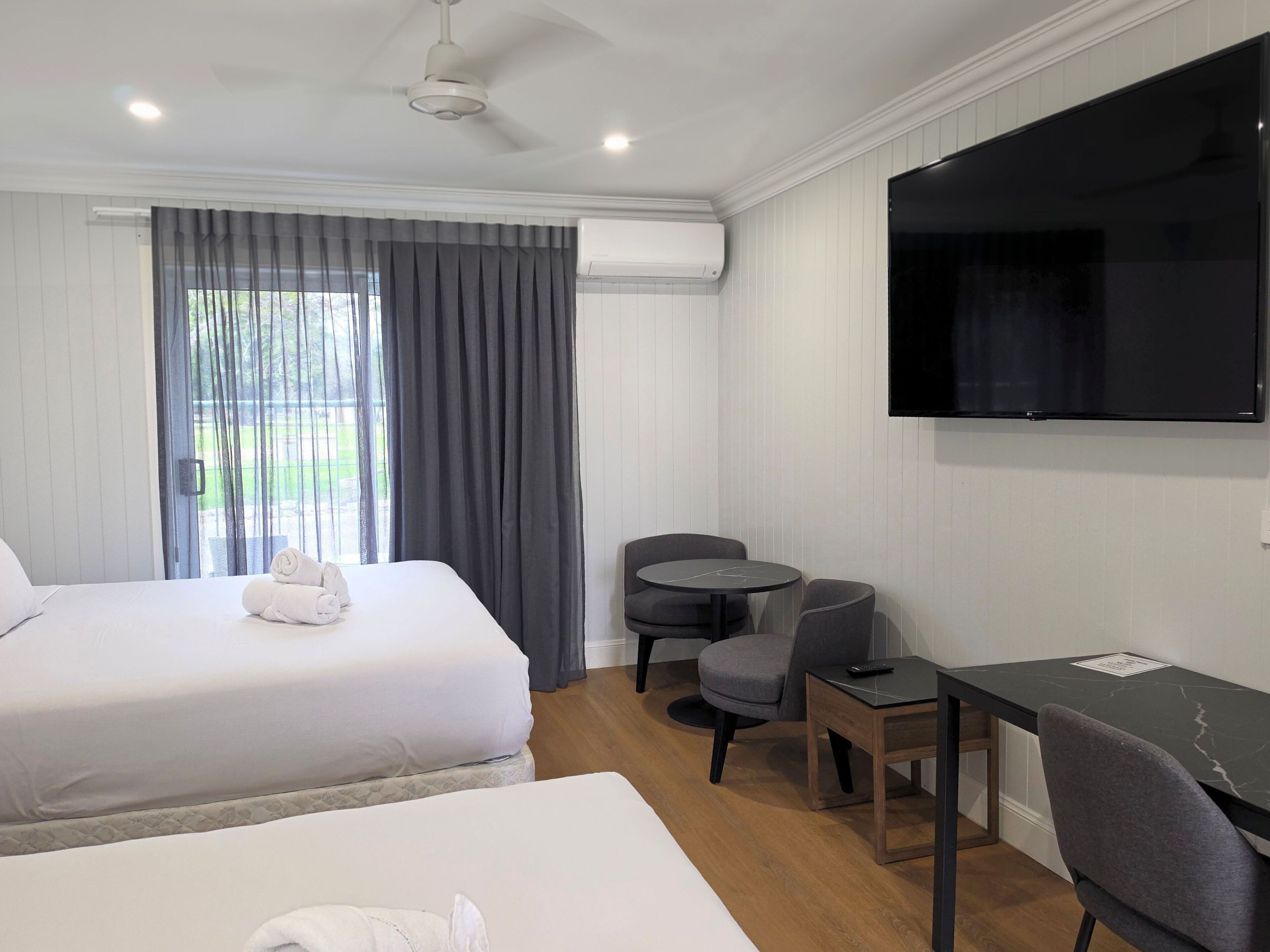 Une chambre d’hôtel avec deux lits, une télévision, une petite table et une chaise.