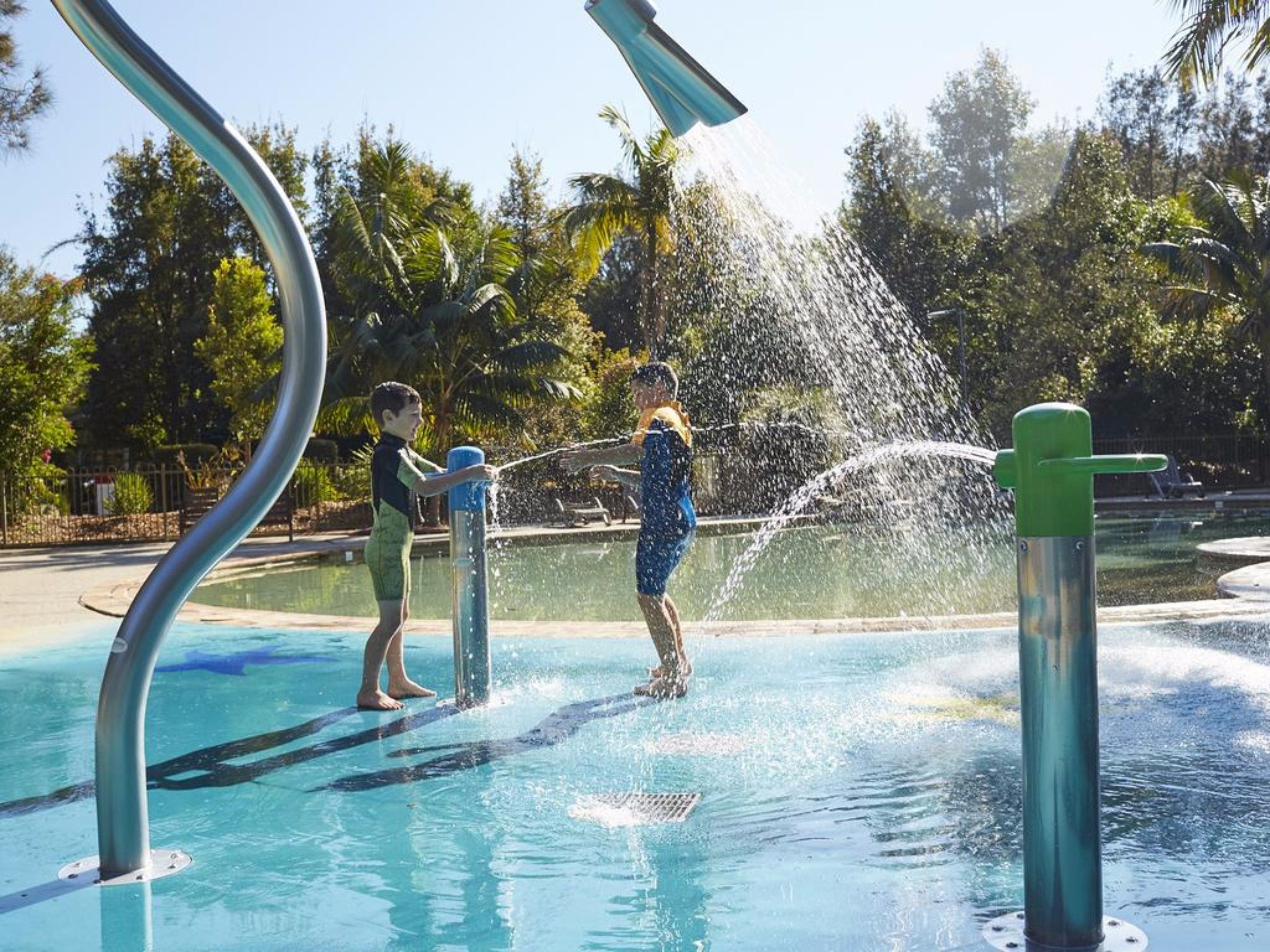 Un'area giochi con acqua, una piscina e strutture metalliche.