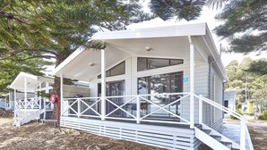 Une maison moderne à deux étages, dotée d’un porche abrité et d’un escalier menant à l’entrée.
