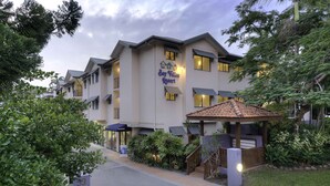 A hotel named Bay Villas Resort with a reception area, outdoor seating, and a well-maintained garden. - Bay Villas Resort (Port Douglas)