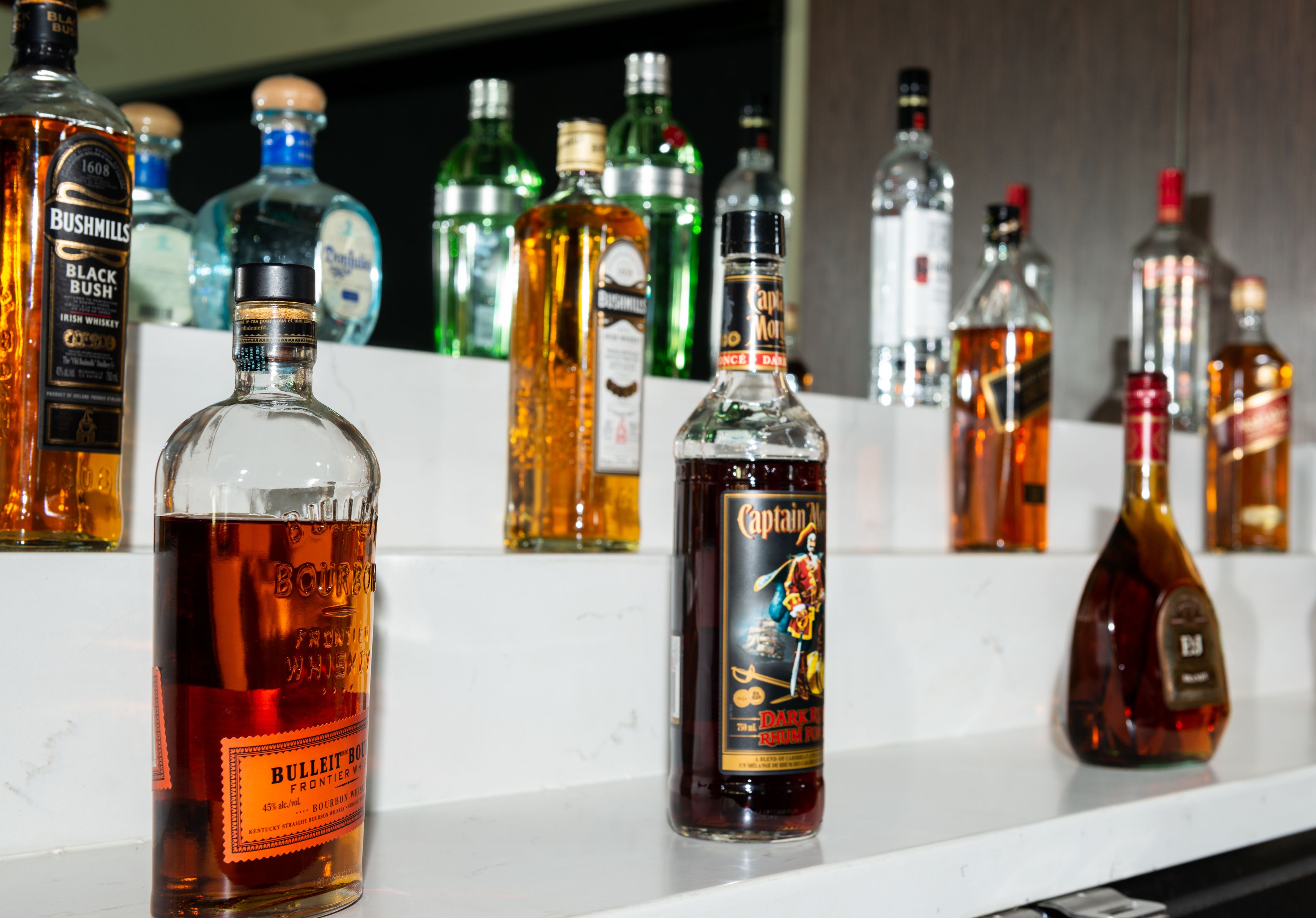Diverse flessen drank op een plank.