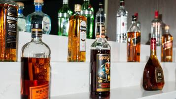 Diverse flessen drank op een plank.